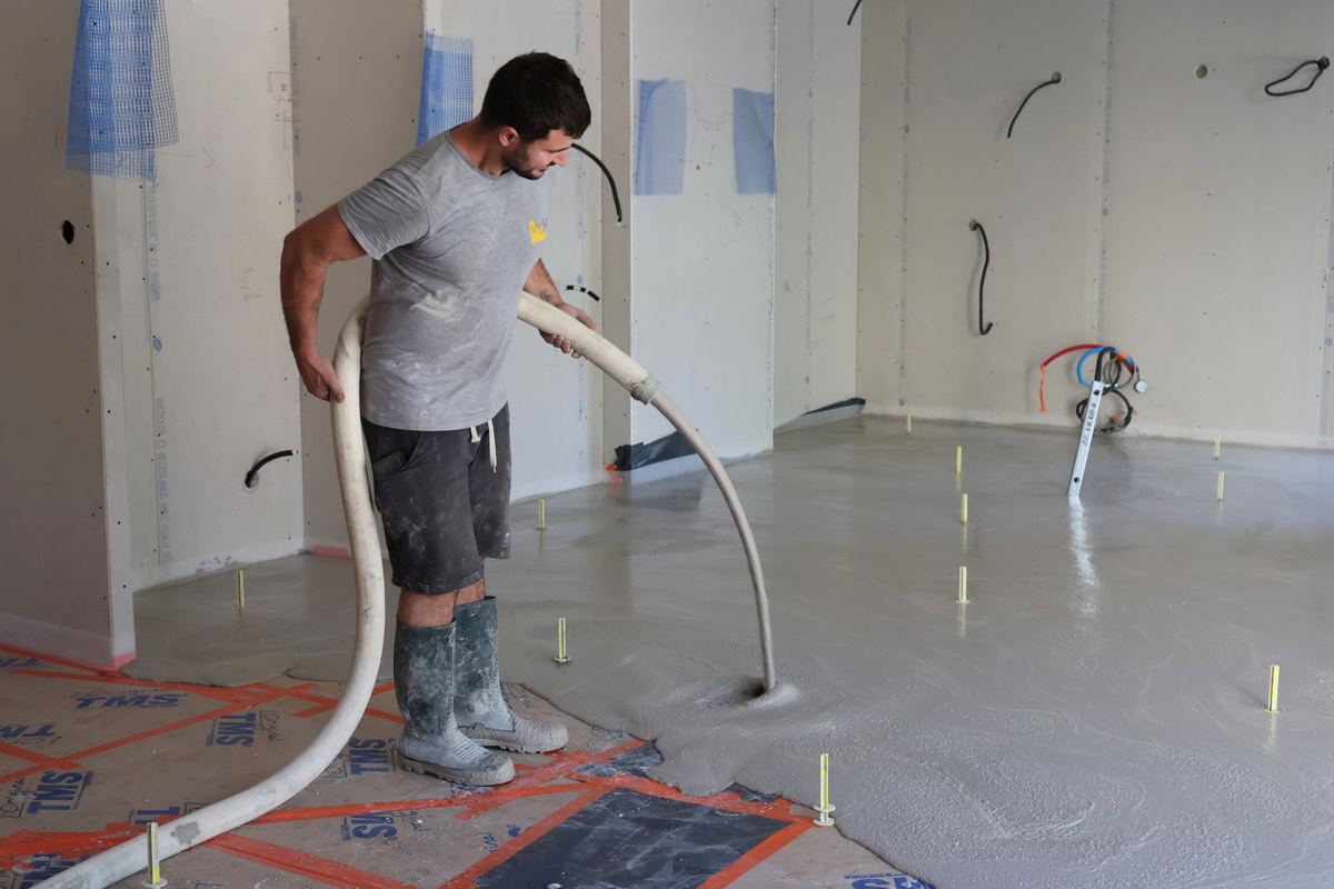 Compagnon DME coulant une chape liquide sur un chantier