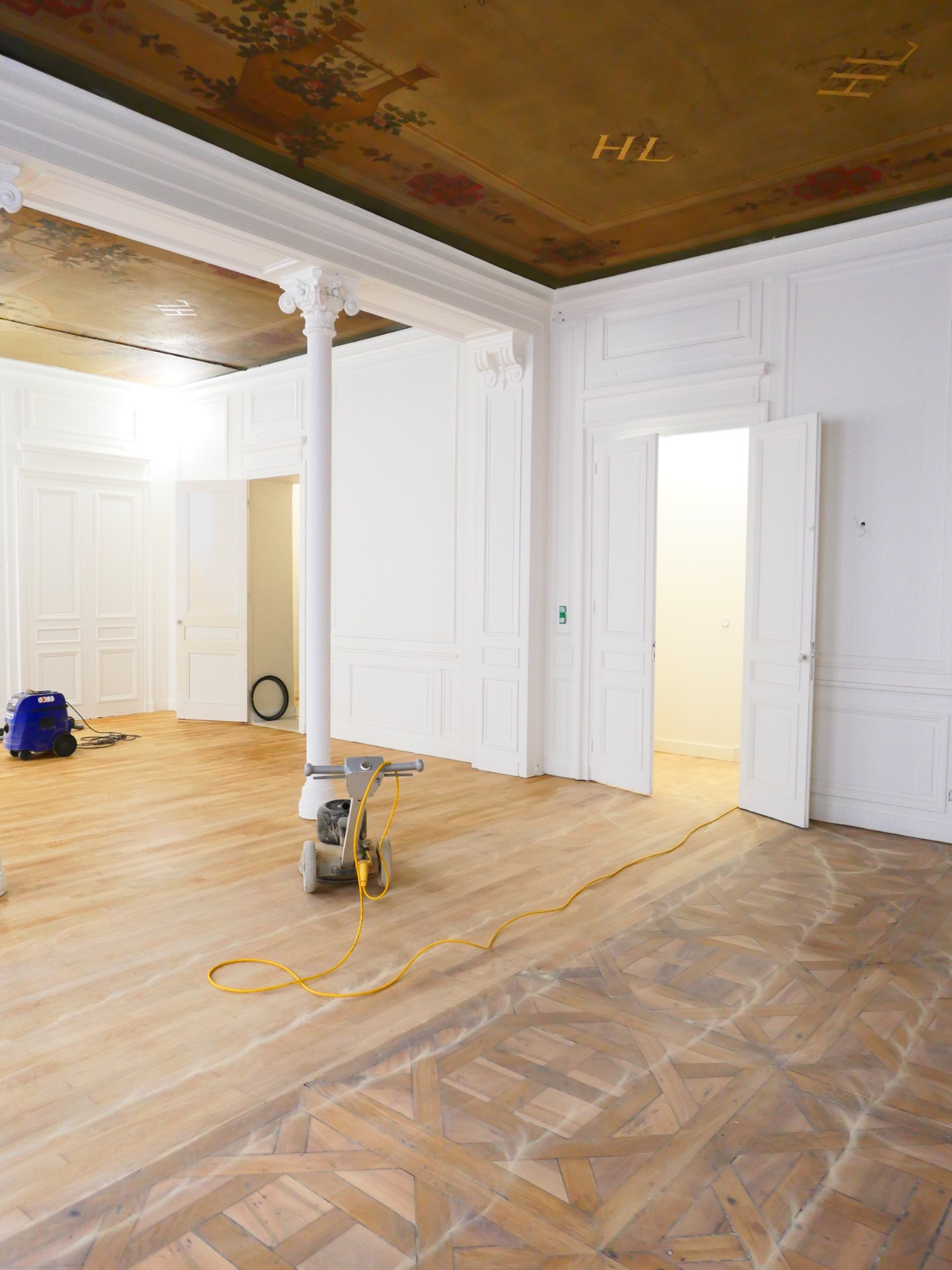 Ponçage d'un parquet ancien à panneaux Versailles dans un appartement ancien en cours de rénovation